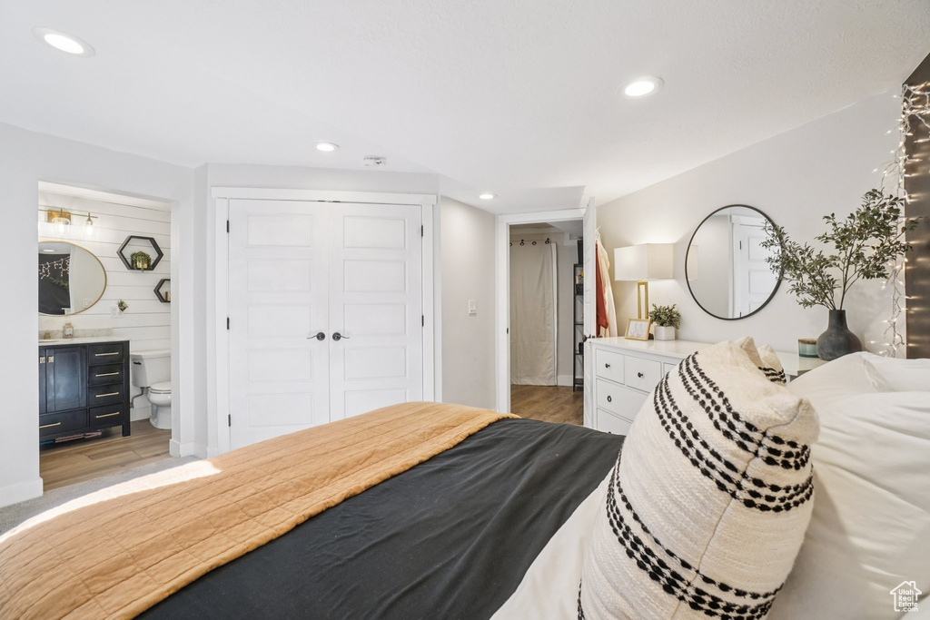 Bedroom featuring light wood-style flooring, recessed lighting, a closet, and ensuite bath