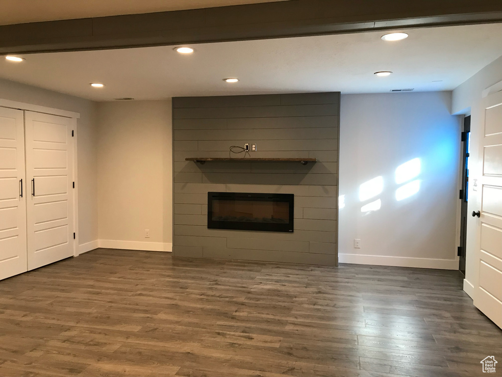 Unfurnished living room featuring a fireplace, dark wood finished floors, and recessed lighting
