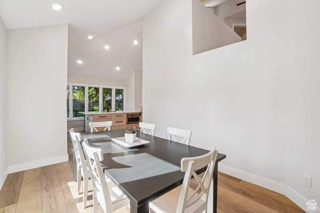 Dining room featuring light wood-type flooring, recessed lighting, and high vaulted ceiling