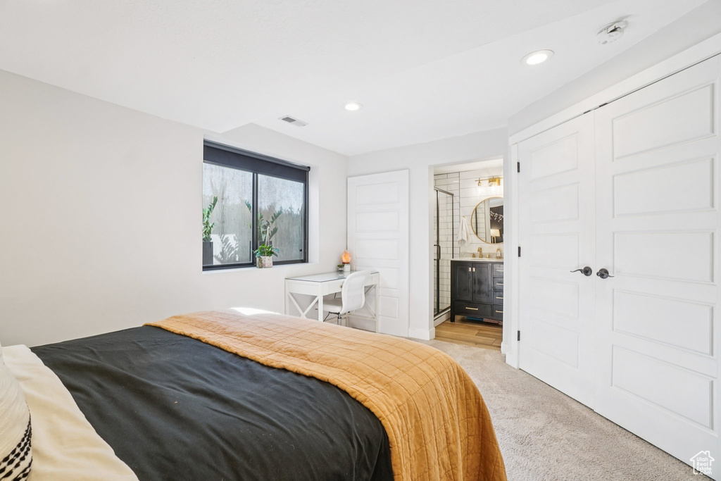 Bedroom with light carpet, recessed lighting, and ensuite bathroom