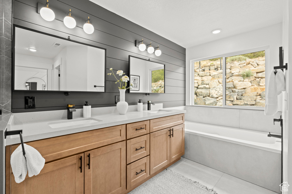 Bathroom featuring double vanity, a garden tub, and tile patterned flooring