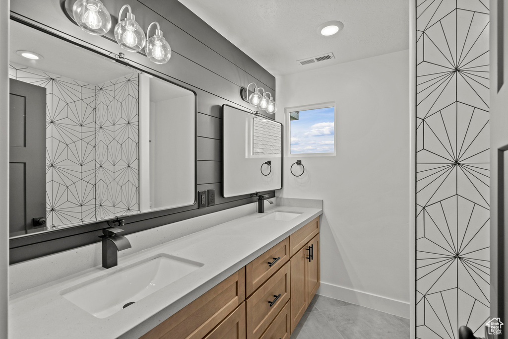 Full bathroom featuring double vanity and baseboards