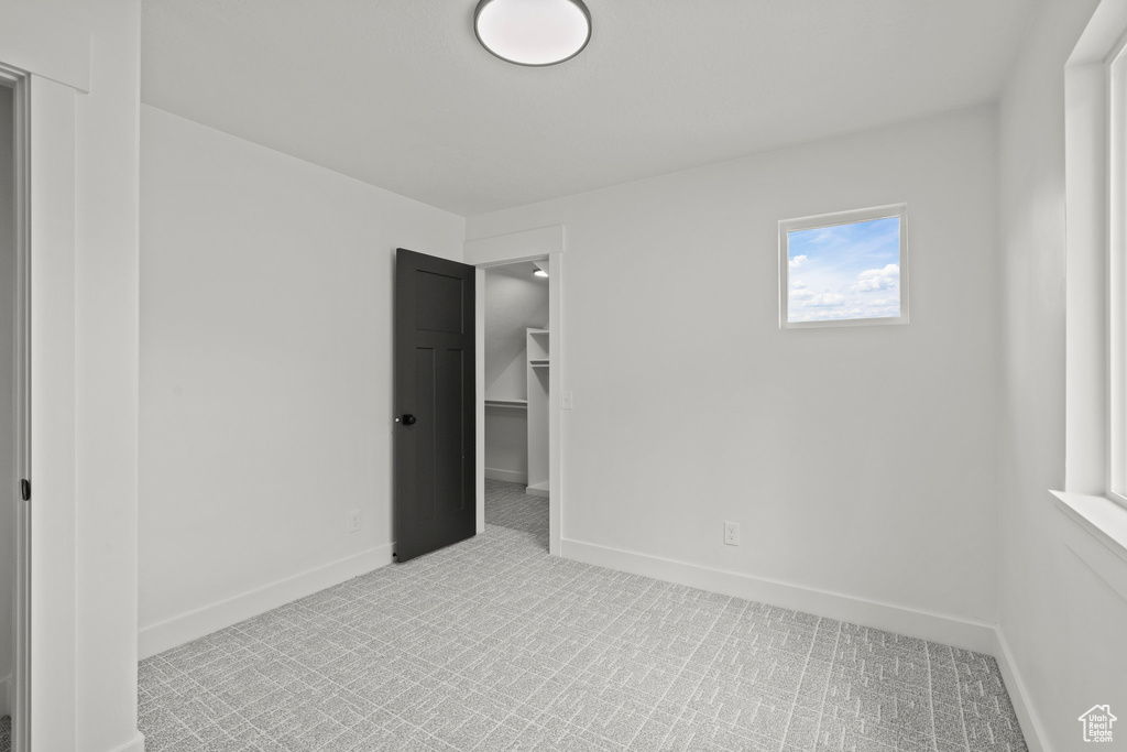 Carpeted spare room featuring baseboards