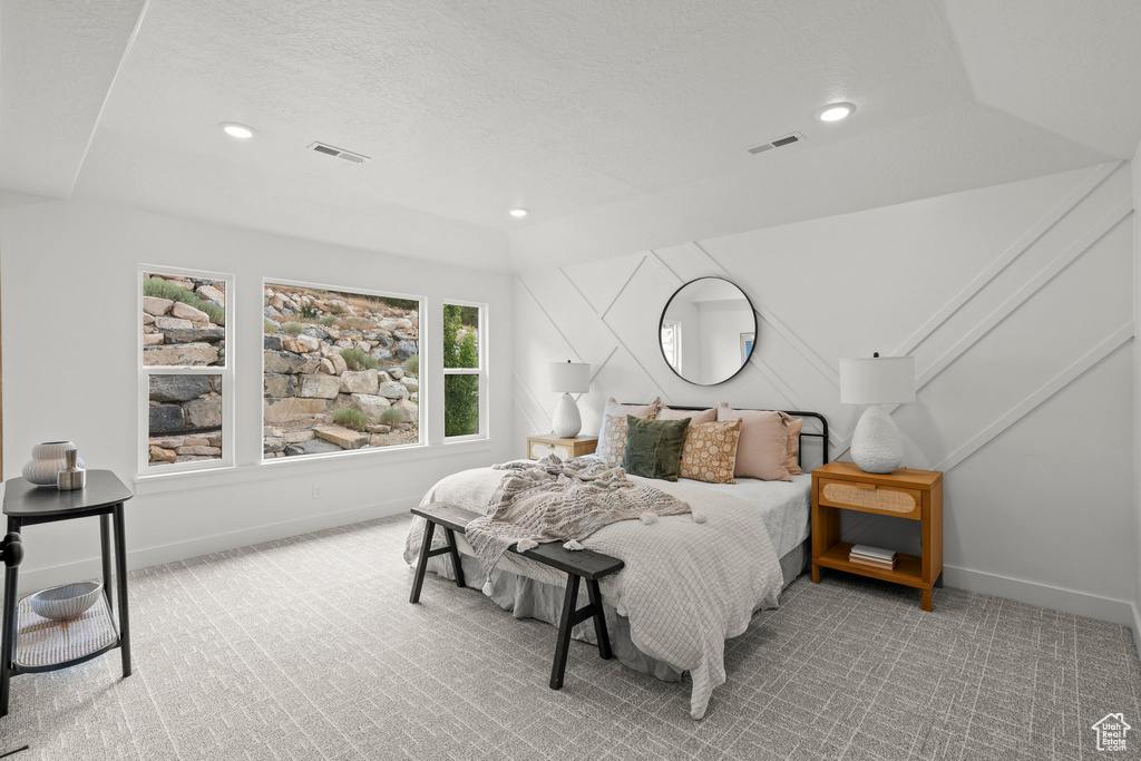 Carpeted bedroom with recessed lighting and a textured ceiling