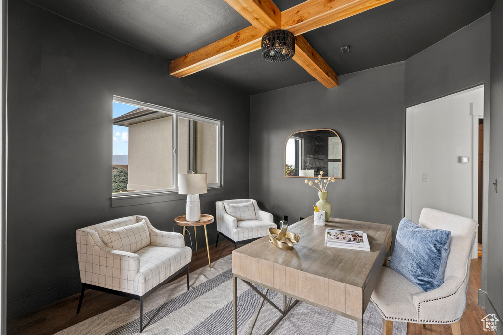 Sitting room with wood finished floors and beam ceiling