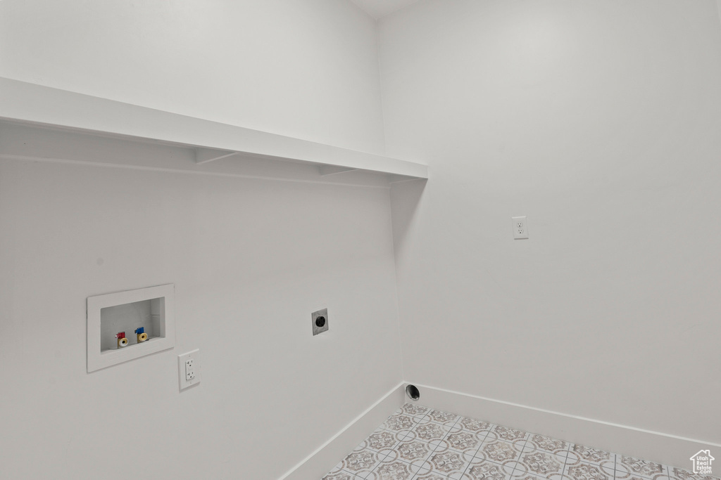 Laundry room with hookup for a washing machine, electric dryer hookup, and light tile patterned floors