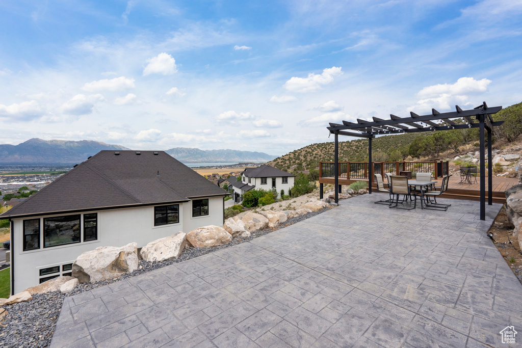 View of patio / terrace with a pergola, a mountain view, and outdoor dining area