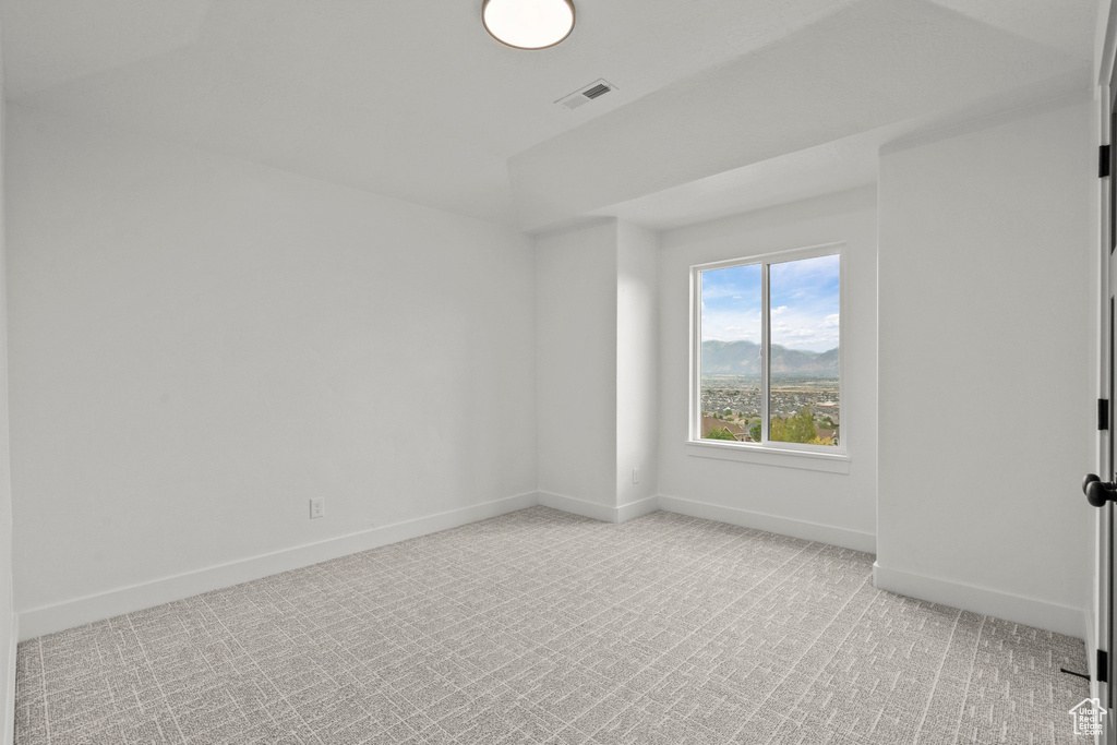 Spare room featuring light colored carpet and baseboards