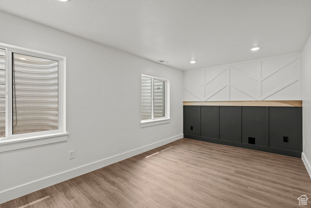 Unfurnished room with wood finished floors and recessed lighting