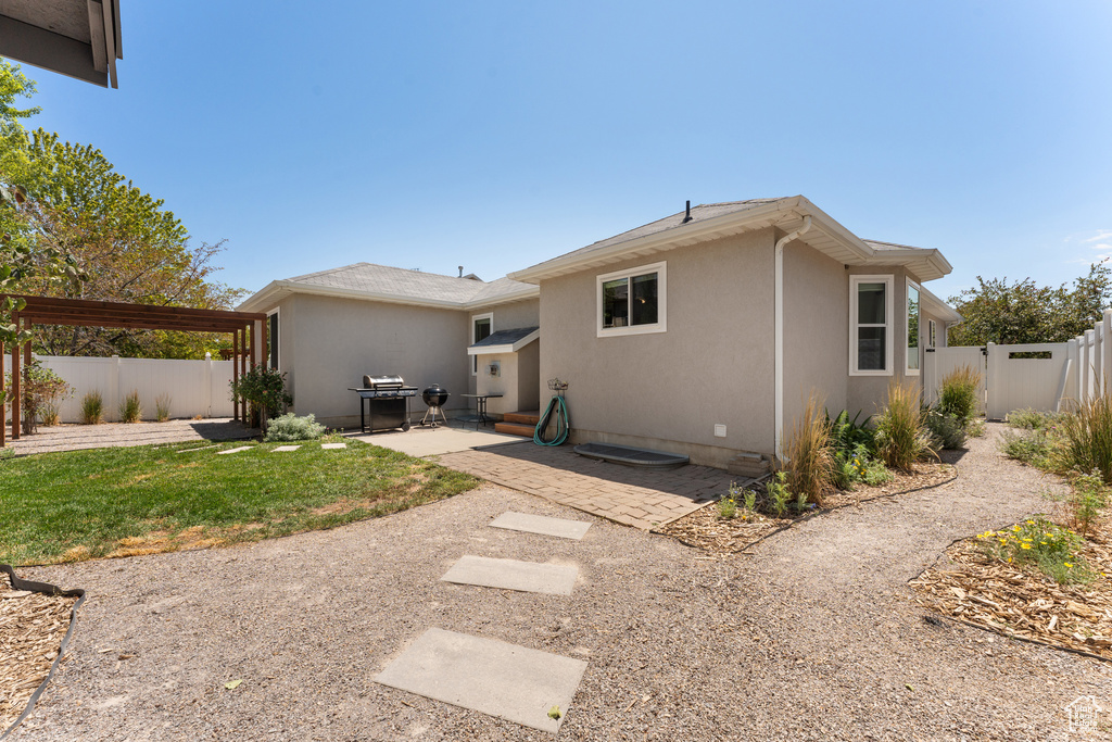 Back of house with a patio area, a fenced backyard, and stucco siding