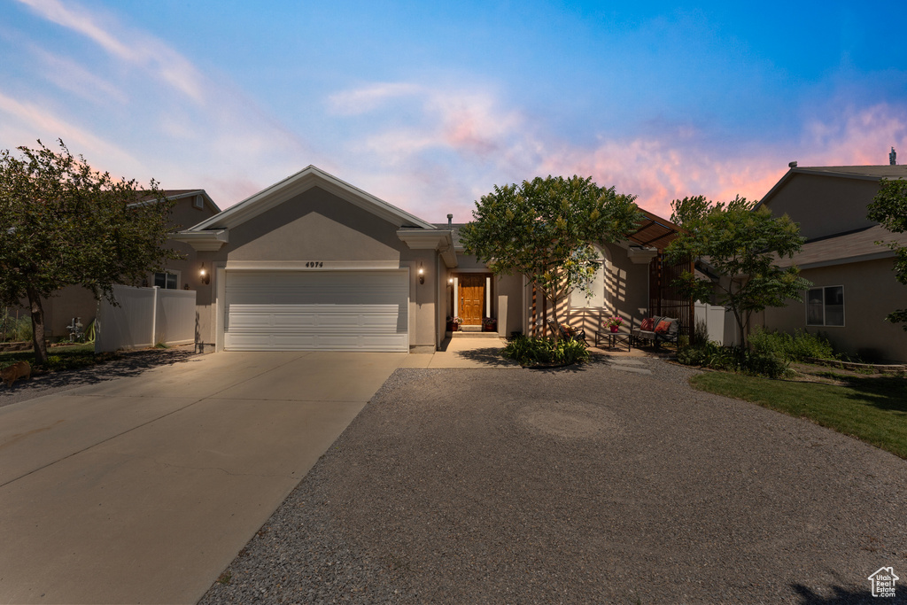 Ranch-style house featuring driveway, a garage, and stucco siding
