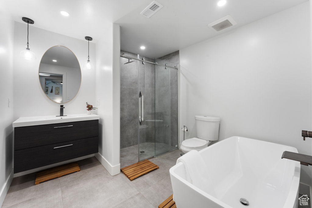Bathroom with vanity, a shower stall, a freestanding tub, and recessed lighting