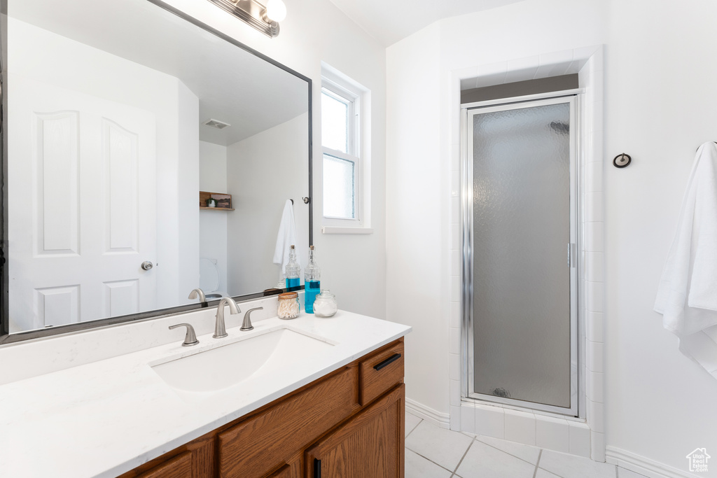 Full bath featuring vanity, a stall shower, and tile patterned flooring