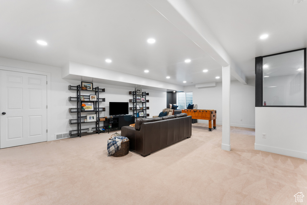Living room featuring light carpet, recessed lighting, and an AC wall unit