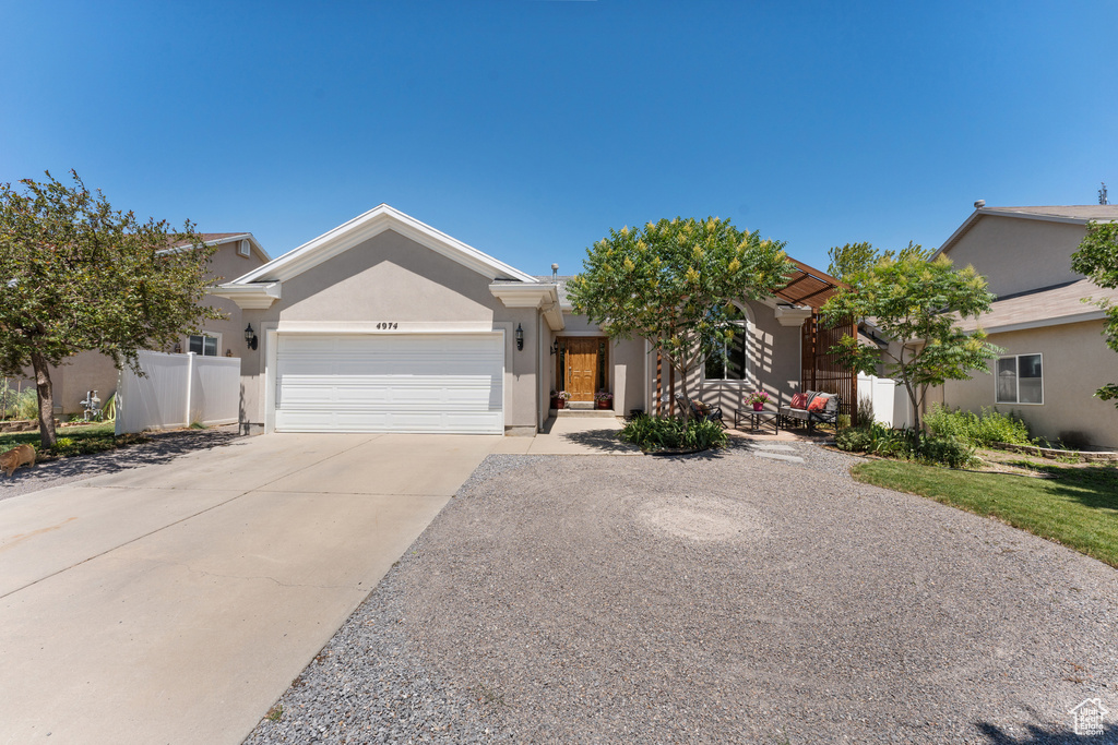 View of front facade with a garage, concrete driveway, and stucco siding