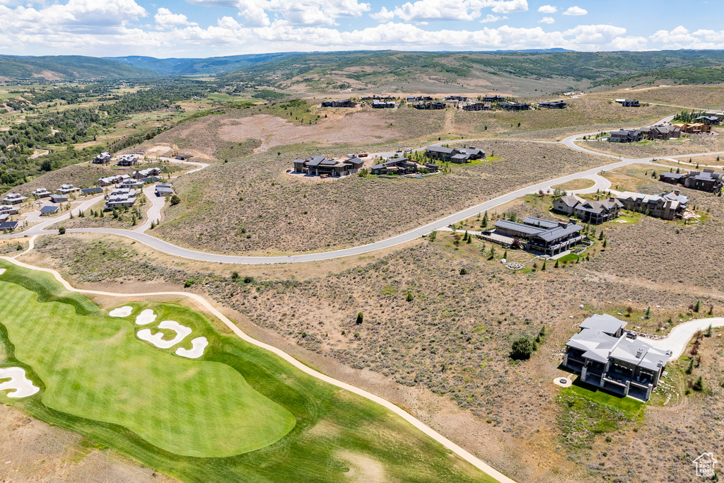Drone / aerial view of a mountain backdrop and a local golf course