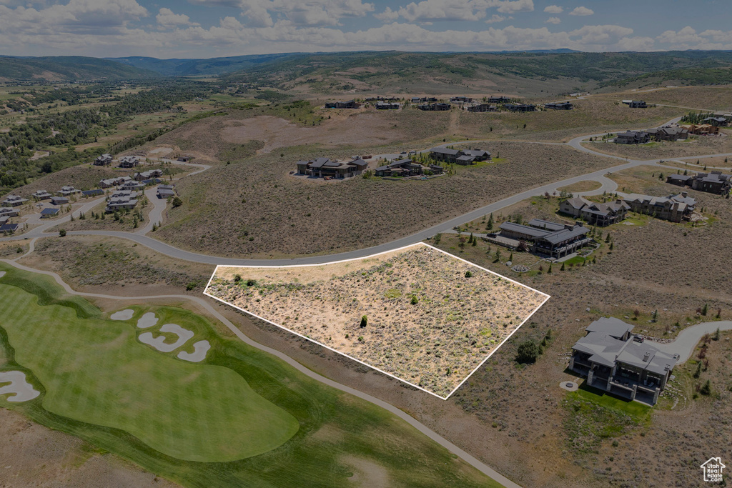 Aerial overview of property's location featuring property parcel outlined, mountains, and a golf course