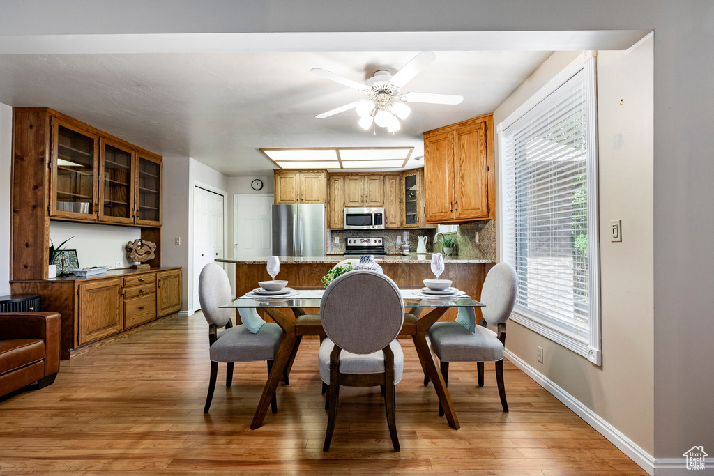 Dining room with a ceiling fan and light wood-type flooring