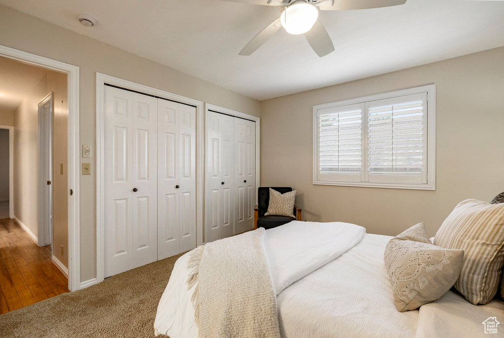 Bedroom featuring two closets, ceiling fan, and carpet