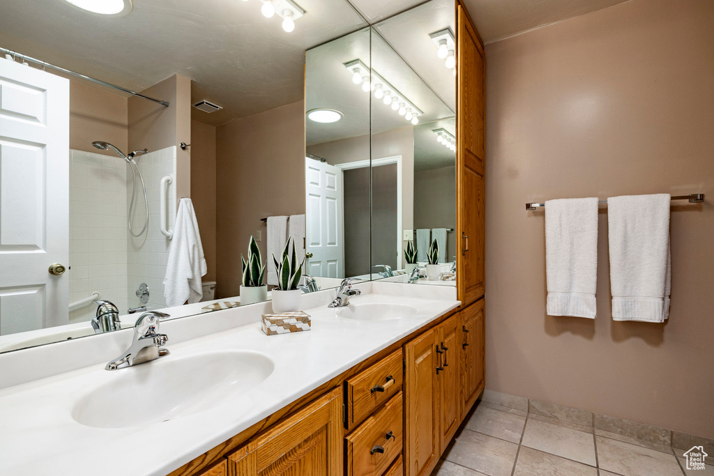 Full bathroom with double vanity and shower / washtub combination