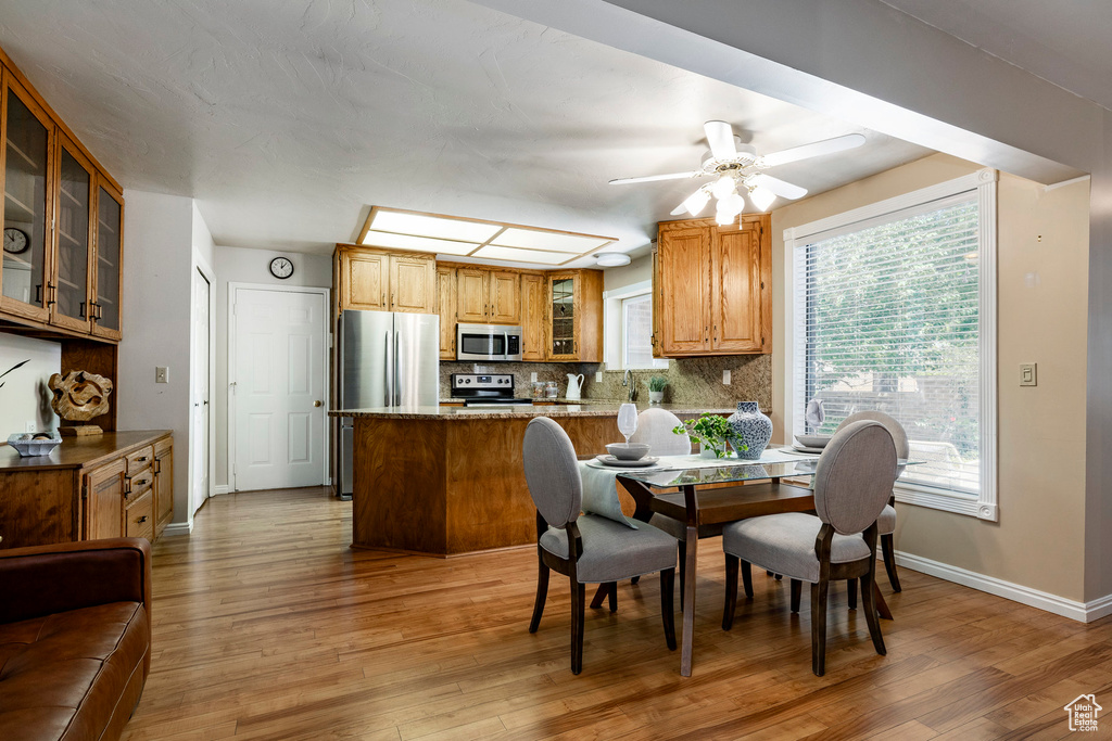 Dining area featuring light wood-type flooring and ceiling fan