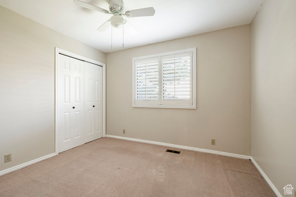 Unfurnished bedroom with carpet flooring, a closet, and ceiling fan
