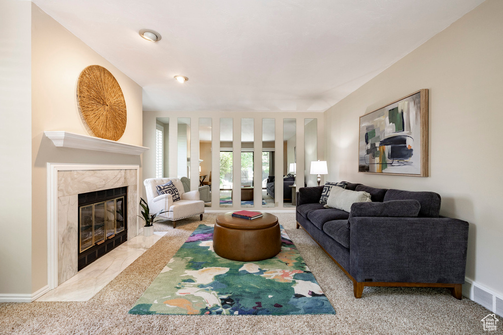Living area with a premium fireplace and carpet floors