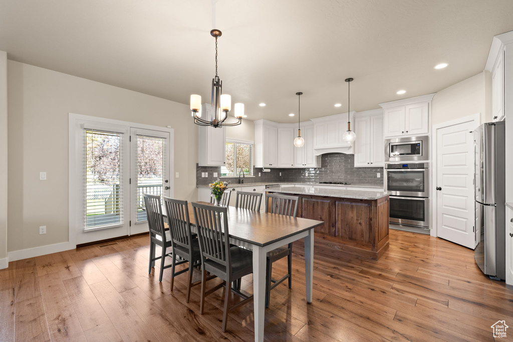 Dining room featuring a chandelier, wood-type flooring, and recessed lighting