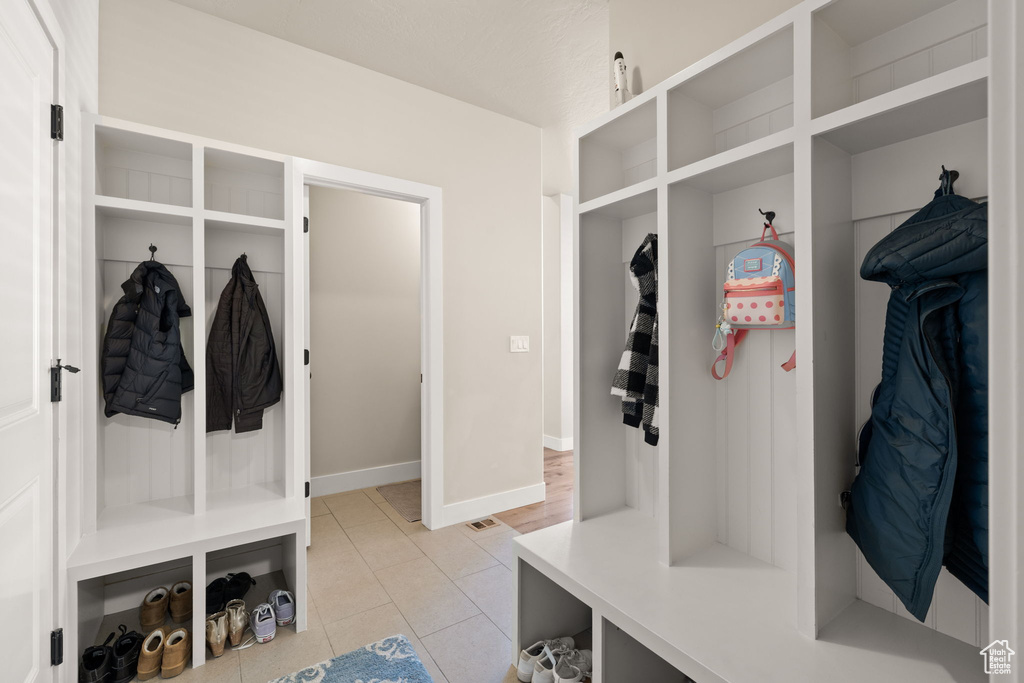 Mudroom featuring light tile patterned floors and baseboards
