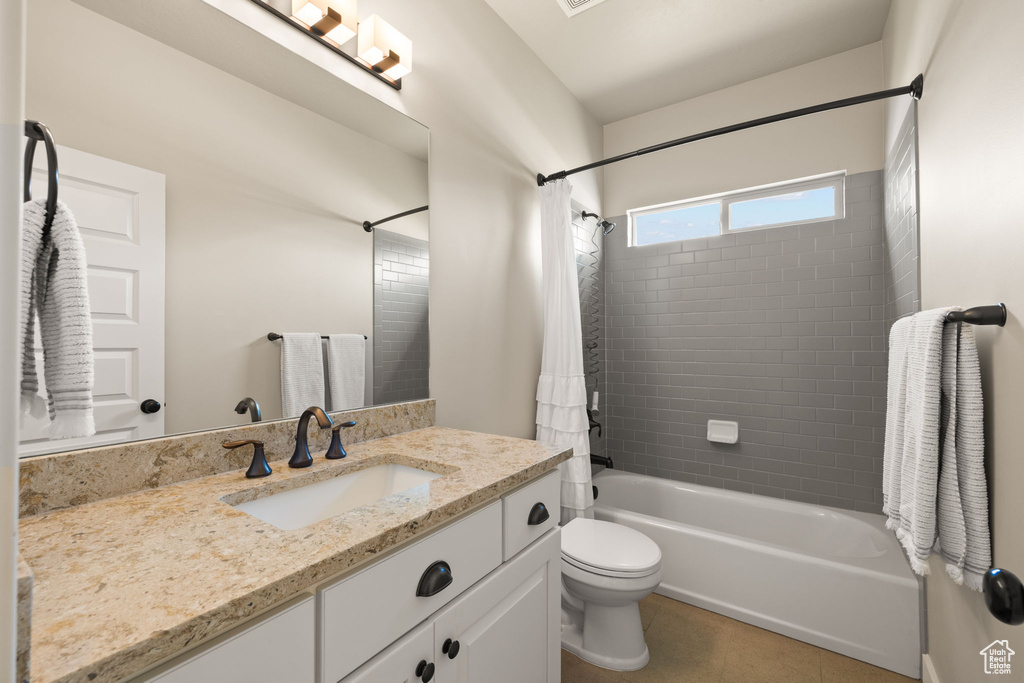 Bathroom with vanity, shower / bathtub combination with curtain, and tile patterned flooring