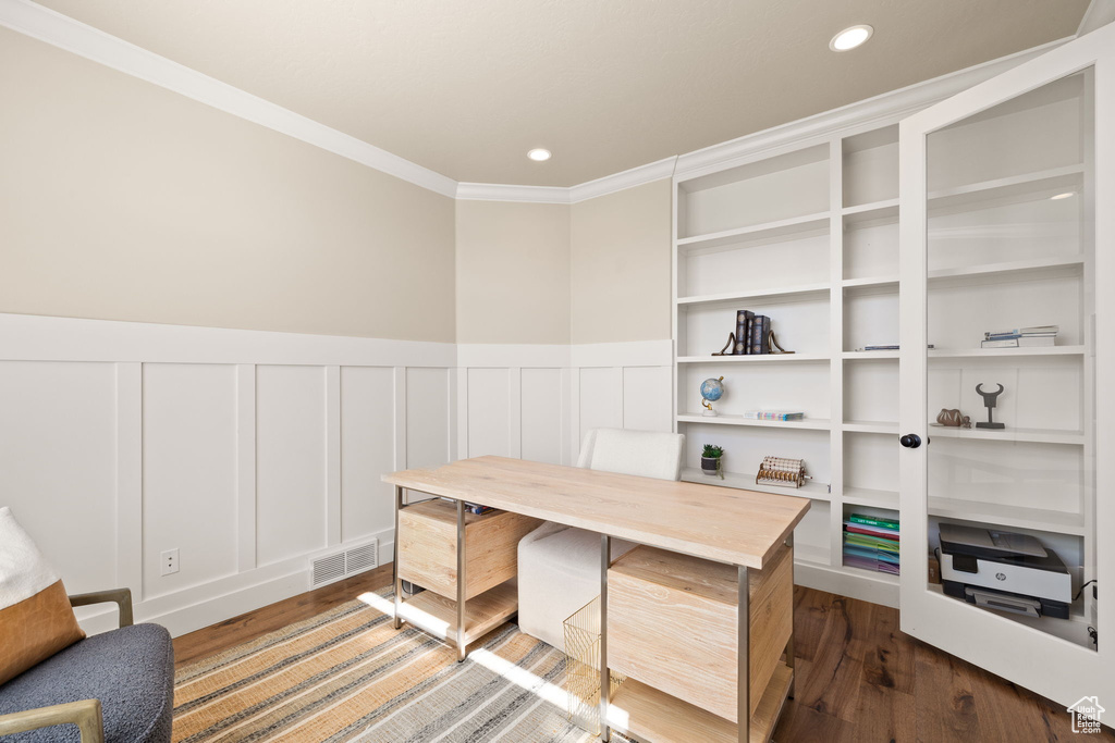 Office space featuring wood finished floors, a decorative wall, crown molding, a wainscoted wall, and recessed lighting