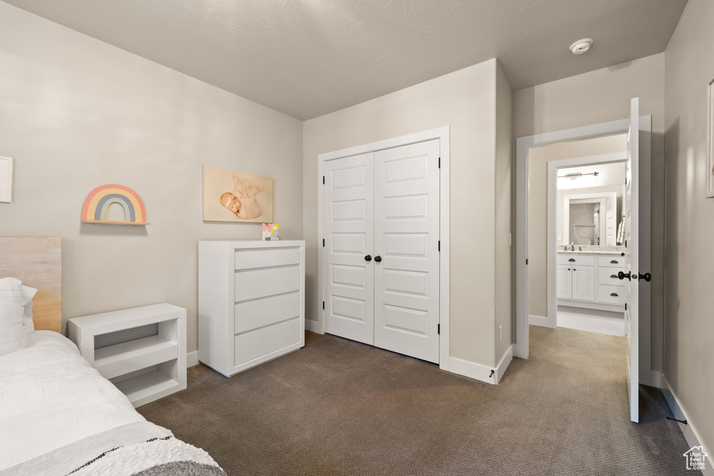 Bedroom featuring dark colored carpet and a closet