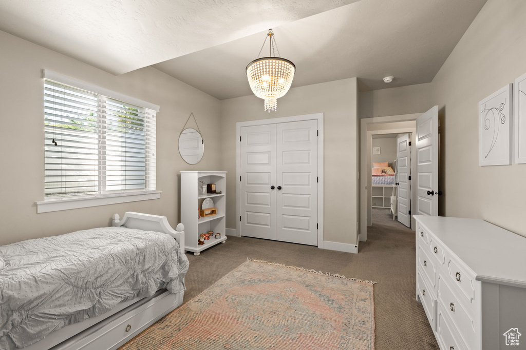Bedroom with a chandelier, carpet floors, and a closet