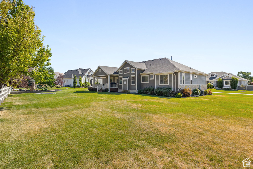 Rear view of house featuring a yard, a residential view, and a porch