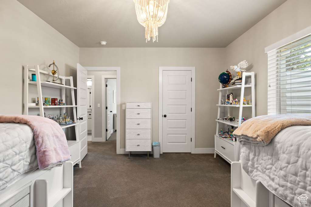 Bedroom featuring a chandelier and dark colored carpet