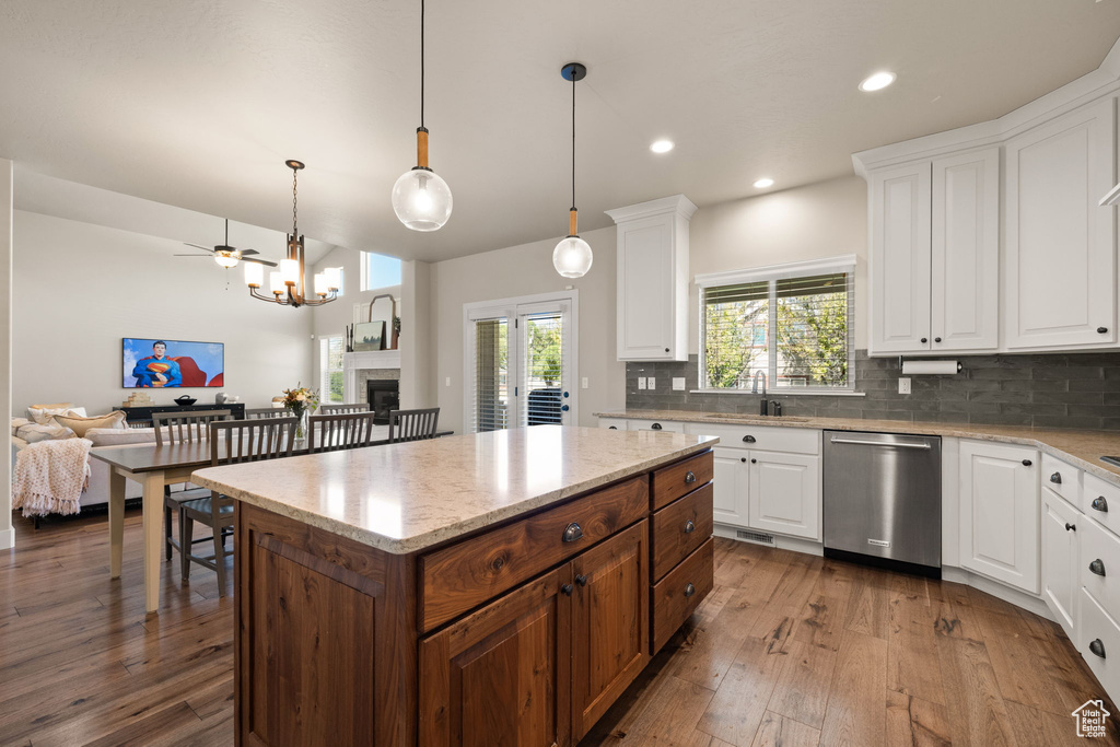Kitchen featuring stainless steel dishwasher, decorative backsplash, open floor plan, white cabinets, and recessed lighting