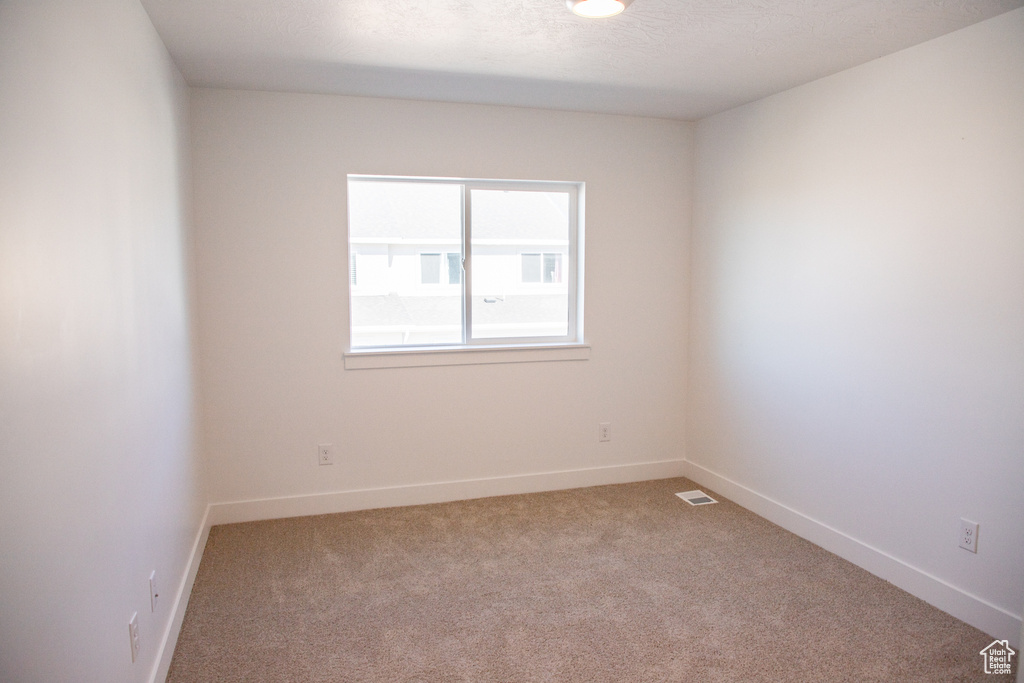Carpeted spare room with baseboards