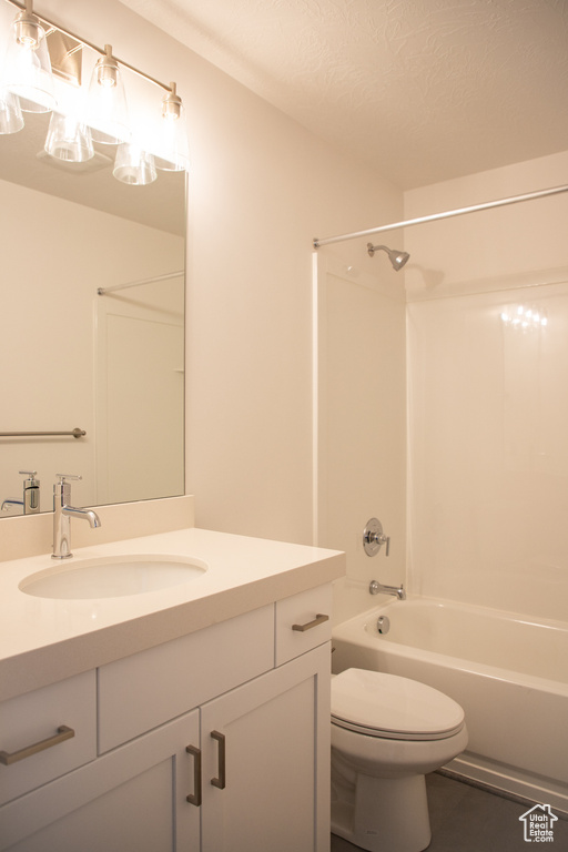 Bathroom with vanity, bathing tub / shower combination, and a textured ceiling