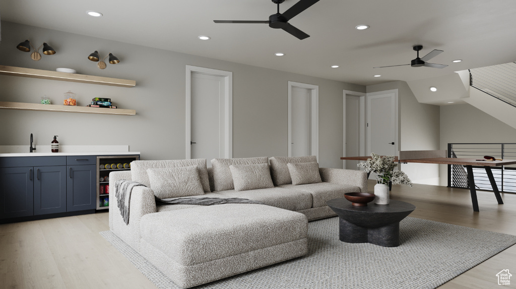 Living area featuring a ceiling fan, light wood finished floors, recessed lighting, and a dry bar