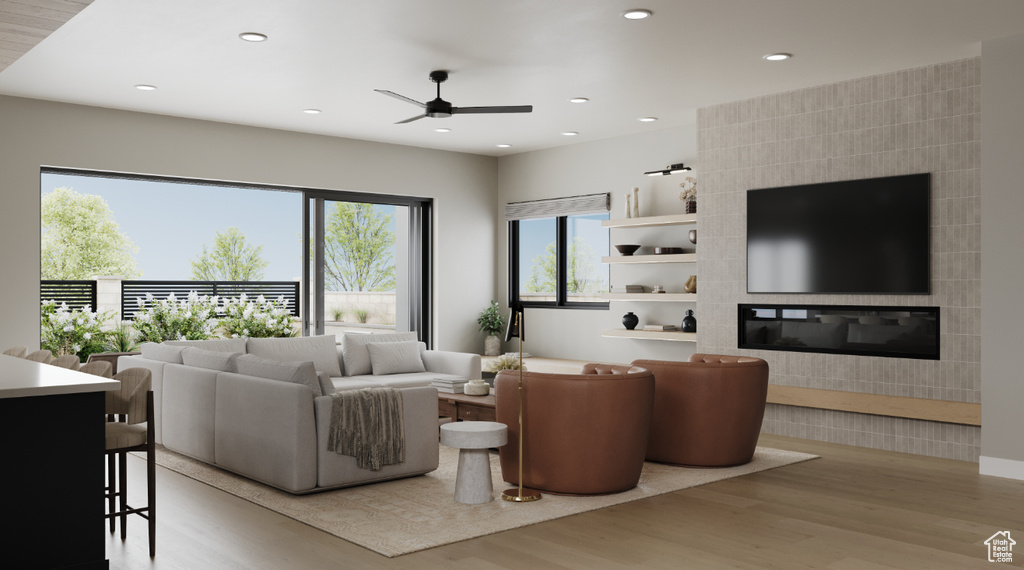 Living room with light wood-style floors, ceiling fan, recessed lighting, and a tile fireplace