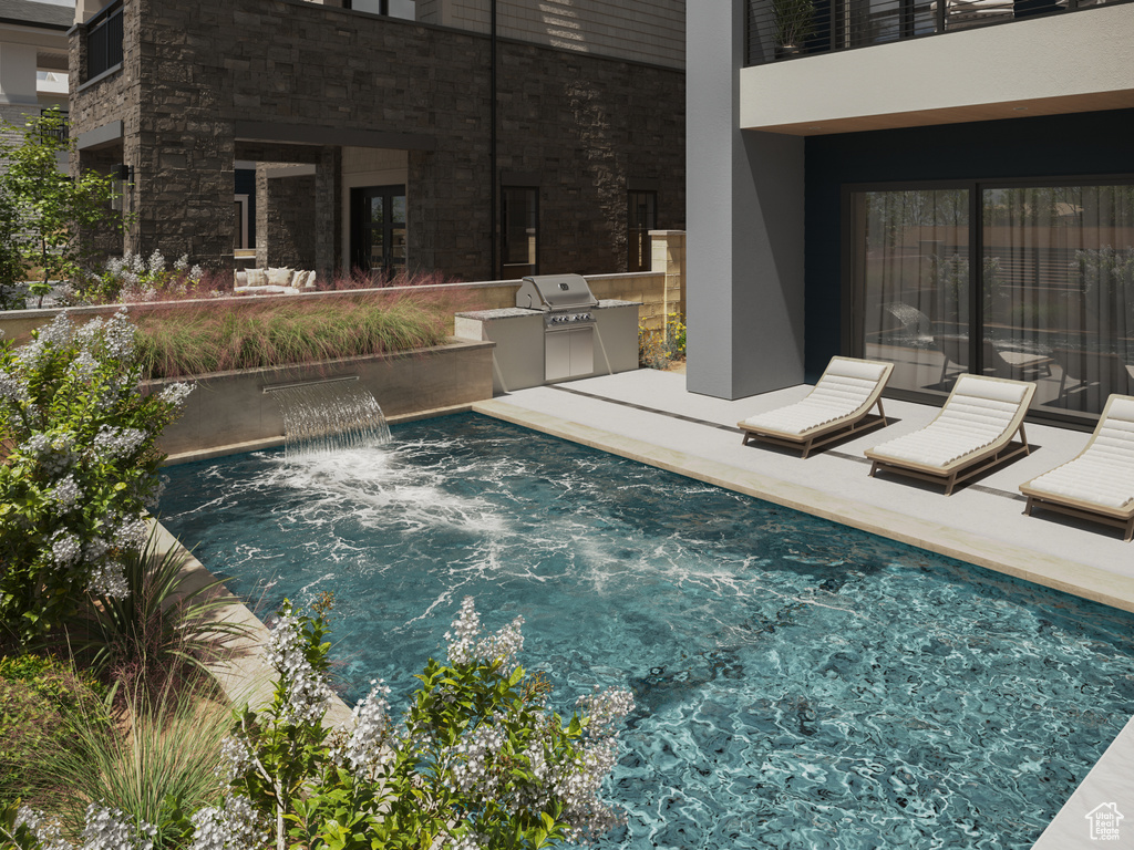 Swimming pool featuring an outdoor kitchen and a patio