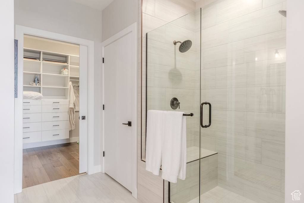 Bathroom featuring a shower stall and a walk in closet