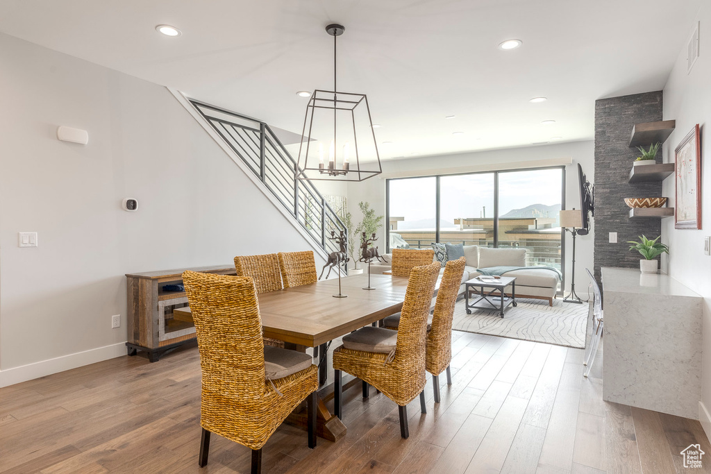 Dining room featuring stairs, a chandelier, wood finished floors, and recessed lighting