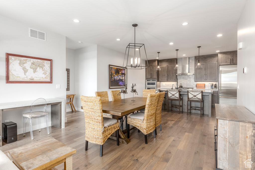 Dining space featuring recessed lighting, light wood-type flooring, and a chandelier