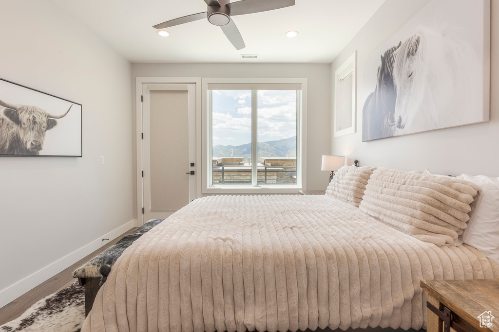 Bedroom featuring wood finished floors, recessed lighting, a ceiling fan, and a mountain view