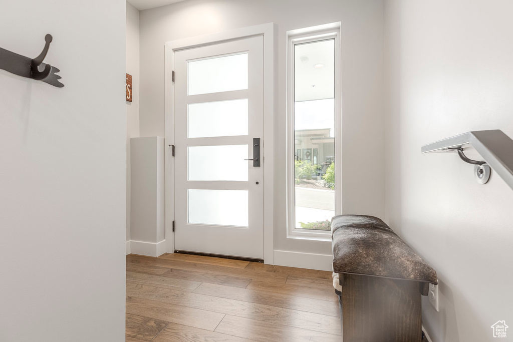 Doorway to outside featuring hardwood / wood-style flooring and baseboards