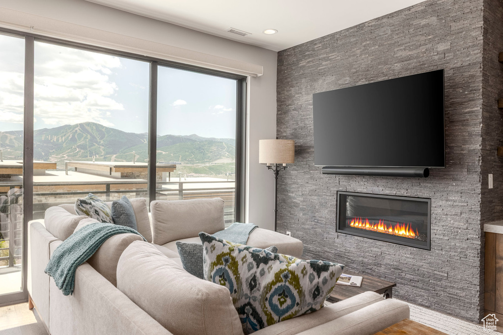 Living room featuring wood finished floors, a fireplace, and recessed lighting