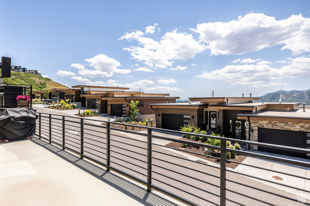 View of front of house featuring a balcony, a mountain view, an attached garage, and stone siding