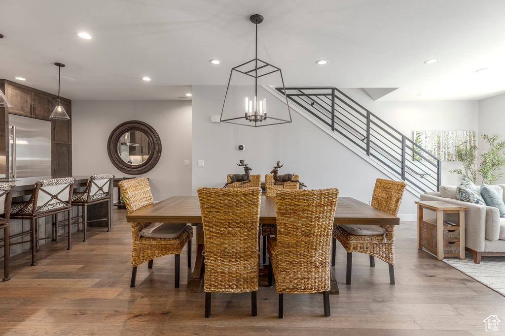 Dining room featuring light wood finished floors, recessed lighting, stairway, and a chandelier