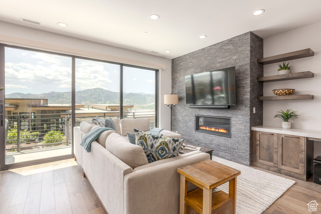 Living area featuring a large fireplace, wood finished floors, and recessed lighting